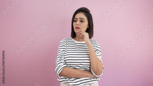 Close-up of unhappy confused thoughtful young Asian woman Thinking deep problem solution feels disappointment depressed, isolated against pink background.