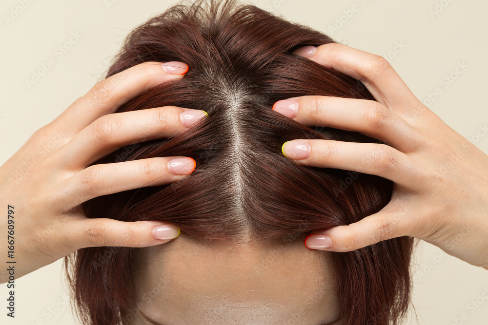 Naklejka premium 若いアジア人の女性は頭皮をマッサージしています。