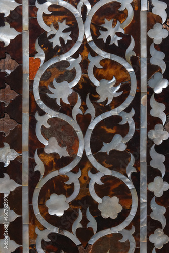 фотографія Elegant inlaid mother-of-pearl motif on a richly colored textured surface