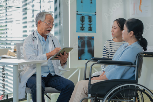 Fotografia Asian daughter accompanies senior mother for medical consultation with doctor using digital health technology