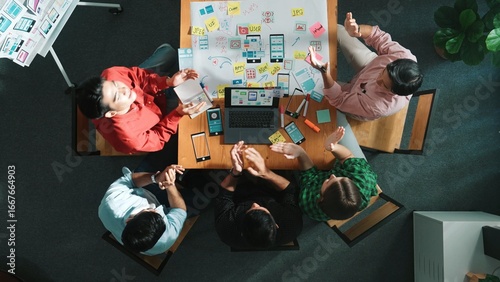 Photos Top view of project manager using laptop working on Ux Ui design for mobile phone interface while marketing team designing software program by using brainstorming mind map