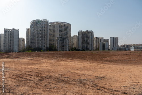 Undeveloped land with roads and distant city skyscrapers