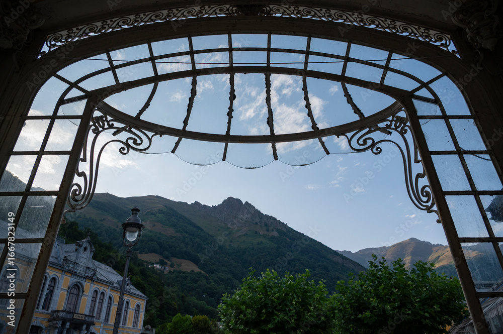Fototapeta premium Historical architecture in Cauteret highlights its charm against the backdrop of majestic mountains, creating a picturesque view during a calm afternoon.