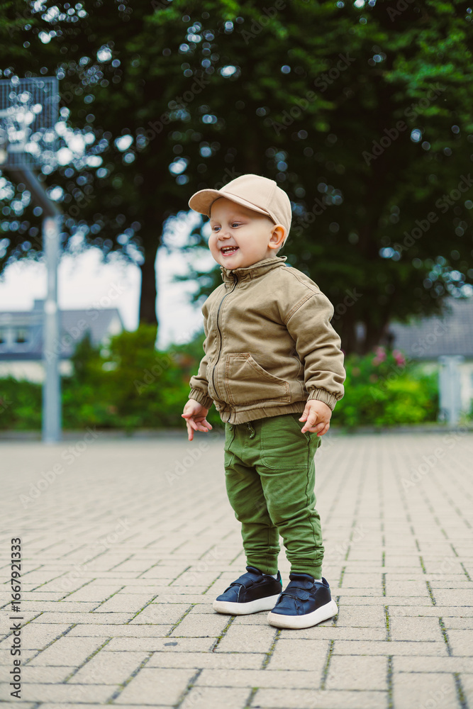 Fototapeta premium A joyful toddler in casual clothing enjoys playful moments in a vibrant park, showcasing innocence and energy while exploring, all with a big smile radiating joy and excitement for life