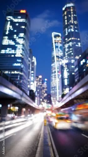 A breathtaking time-lapse video with a subtle vertical dolly video, showing a bustling urban highway intersection at dusk from a low angle. Vivid red and white light trails flow past neon-lit