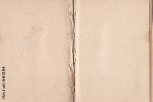 Open old note pad background. Vintage open notebook with missing pages in the middle. Damaged Pages with Torn Center Fold. Open Antique Book