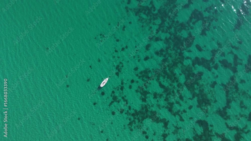 drone top view of a white boat in the sea