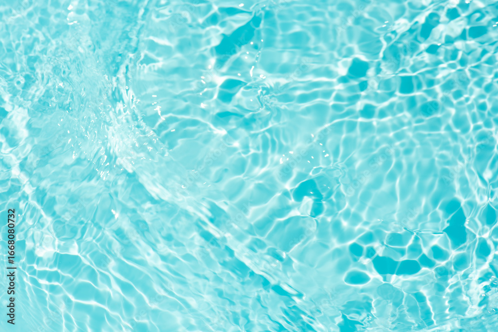 Obraz premium Blue water with ripples on the surface. Defocus blurred transparent blue colored clear calm water surface texture with splashes and bubbles. Water waves with shining pattern texture background.