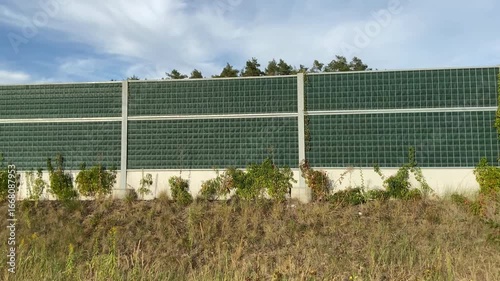  Traffic noise screen, also known as a noise barrier or soundwall along a high speed road