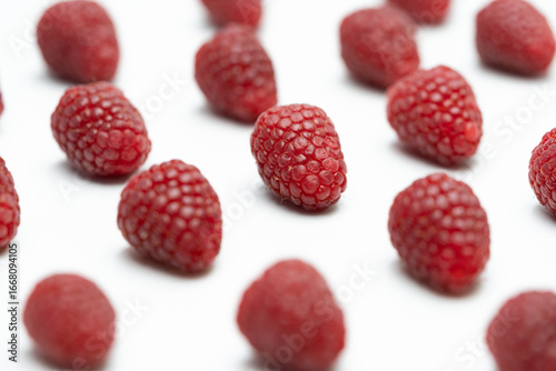 Raspberries on White Background – One in Sharp Focus, Others Blurred