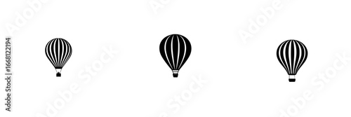 Hot air balloons in a clear sky drifting gently during sunrise over an open field