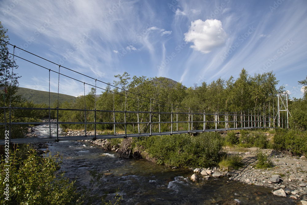 A pedestrian suspension bridge over a stream in Kungsladen, Sweden on the trail south from Nikkaluokta A pedestrian suspension bridge over a stream in Kungsladen, Sweden on the trail south from Nikkaluokta