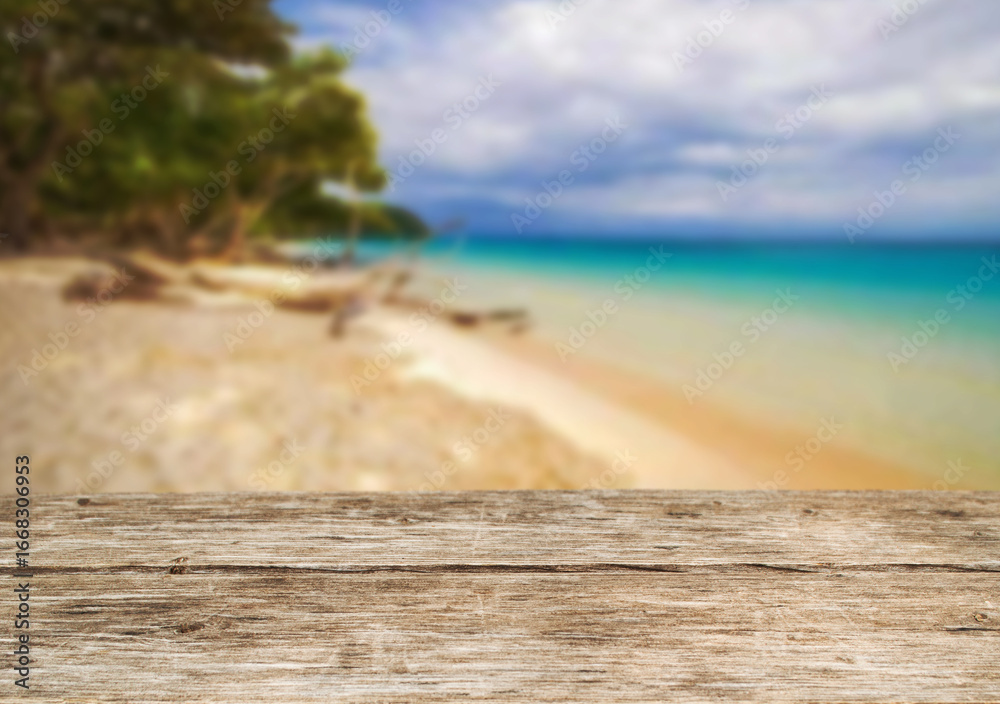 Fototapeta premium Wooden table top on the beach or sea.Party on the beach sunshine time concept.For montage product display or design key visual layout.View of copy space.