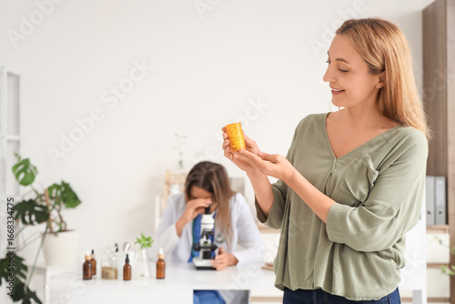 Mature woman with pill bottle at homeopathic doctor's office