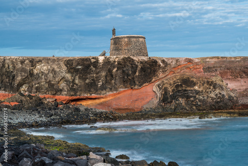 Castillo de las coloradas fortification perched on volcanic cliffs in lanzarote, canary islands
