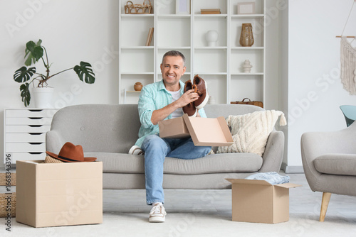 Mature man unpacking box wi...