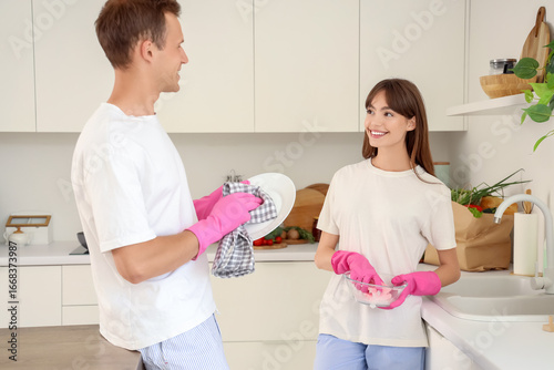 Young couple washing dishes...