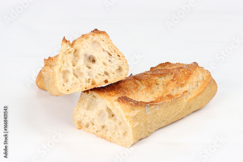 Baguette bread cut in half on a white background