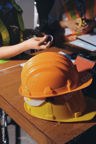 Closeup of team of industrial engineers meeting analyze machinery blueprints consult project on table in manufacturing factory. Working in manufacturing plant or production plant.