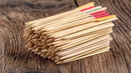 Neat Stack of Wooden Skewers with Colorful Tips on Dark Wood