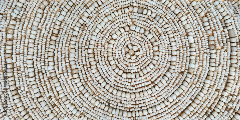 Naklejka premium Background of circular pattern on ivory beads, up close. Traditional handicraft of ivory beads with circular pattern for decoration.