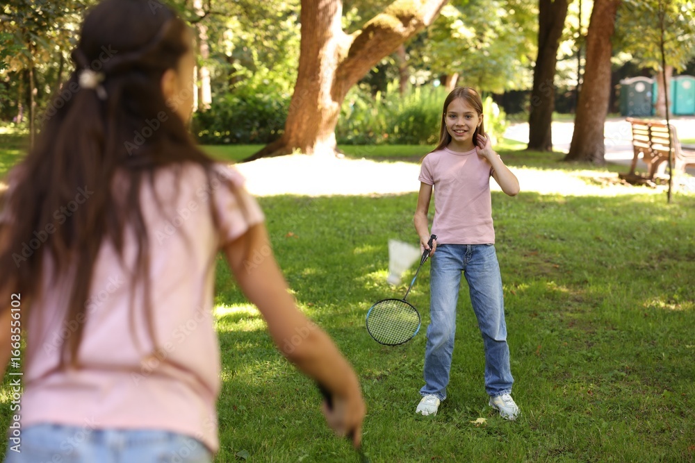 Fototapeta premium Cute little girls playing badminton in park