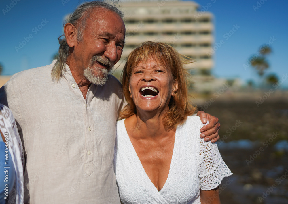 Fototapeta premium Happy senior couple having fun together on the beach during summer vacation - Elderly people lifestyle, love and travel holiday concept