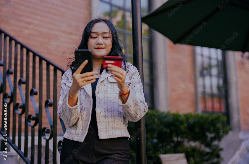 Fototapeta premium Asian businesswoman doing online payment via smart phone and credit card. Web subscriptions e-commerce, checking electronic wallet balance, e-banking and online transactions.