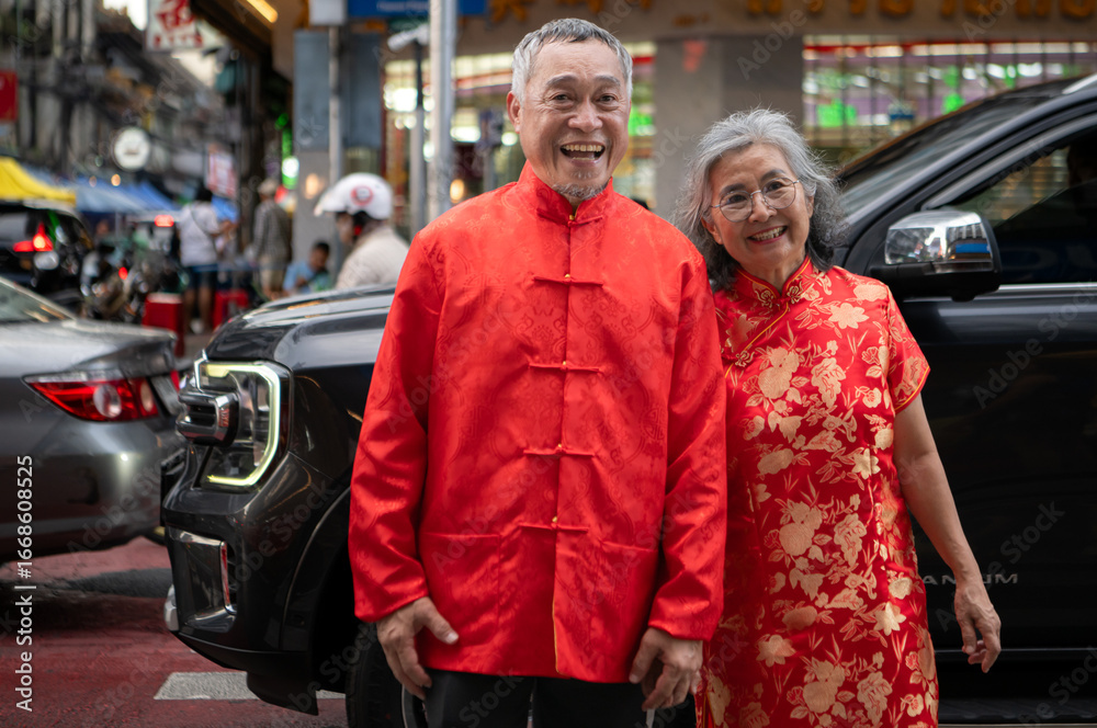 Fototapeta premium A happy senior couple strolls along a Chinatown in Bangkok, Thailand,