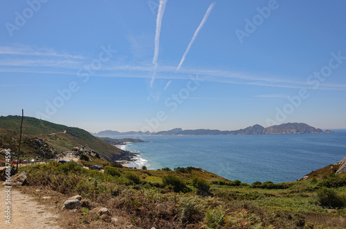 Vista de la costa en día soleado con líneas de aviones