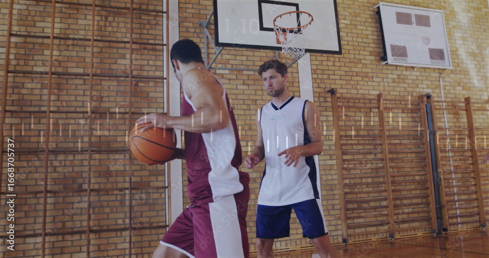 Fototapeta premium Maroon jersey player holding basketball near hoop in school gym, with defender and climbing frames