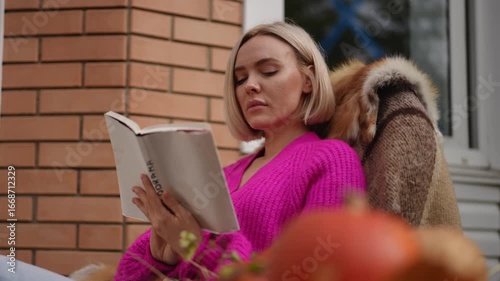 A woman currently enjoying a peaceful moment while reading a book in a cozy outdoor setting surrounded by nature