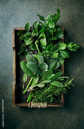 Fresh organic herbs on rustic wooden tray. Top view. Natural food ingredients