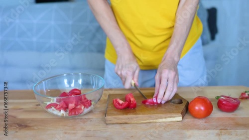 Knife slicing ripe tomatoes on rustic cutting board, preparing vibrant vegetable salad in transparent fullhd bowl video