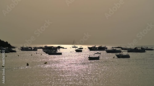 Barcas en el mar, contraluz temprano, por la mañana