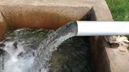 Water flowing from pipe into concrete basin