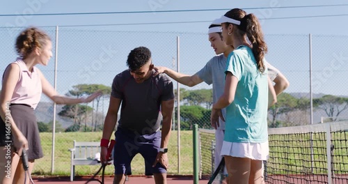 Rally ending diverse doubles teammates huddling and discussing positioning at net with rackets