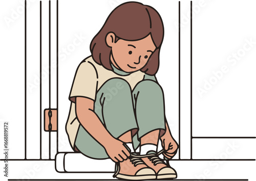 A young girl with brown hair in casual clothes sitting and tying her shoelaces.
