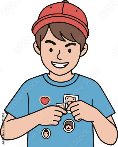 Smiling young boy in a red cap attaching a photo sticker to his blue t-shirt.
