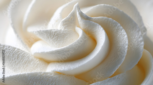 A detailed macro view of fluffy white frosting, showcasing its smooth, swirling peaks and creamy texture.