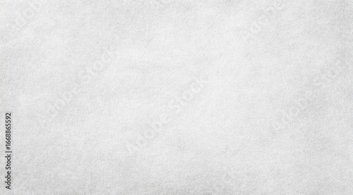 A close-up of a subtly textured, light gray surface with a slightly mottled appearance, suggesting a paper or fabric-like material