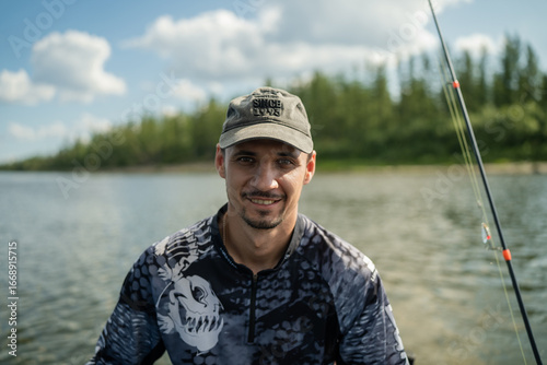 Close-up of fisherman looking at camera against river background