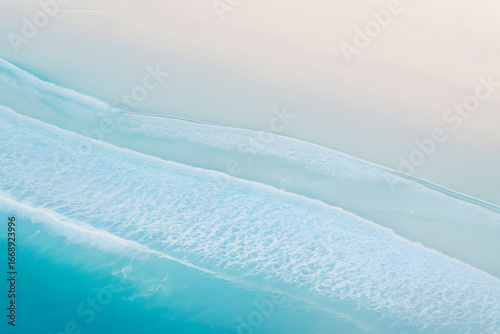 aerial view of turquoise ocean waves and soft sandy beach minimal summer seascape background