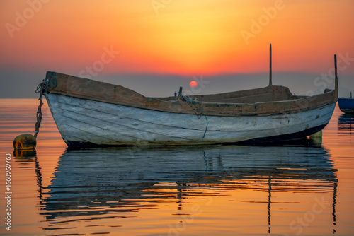 Traditional fishing boat on the Mar Menor in Cartagena, Murcia, Spain, with a spectacular sunrise.