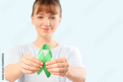 Young woman with green ribb...