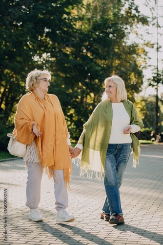 Wallpaper Mural Two senior women holding hands while walking in a park Torontodigital.ca