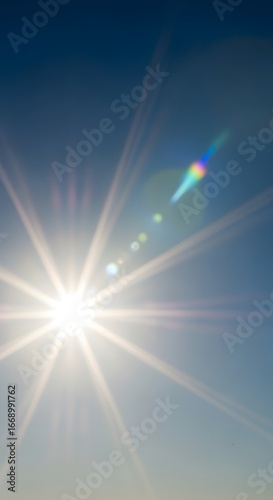 Bright sun with lens flare in the blue sky on a clear day