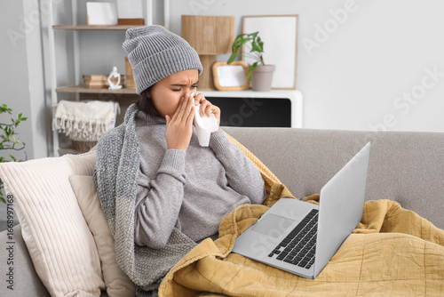 Sick young woman with lapto...