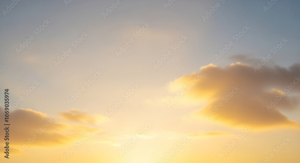 Fototapeta premium Golden hour sky with soft, yellow cloudscape creating a peaceful and serene atmosphere, ideal for tranquil or nature-themed designs