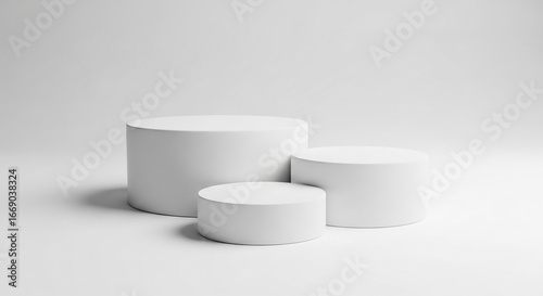 Three white cylindrical podiums on a white background, showcasing a minimalist product display scene, ideal for mockup or presentation purposes.  Free space for text.